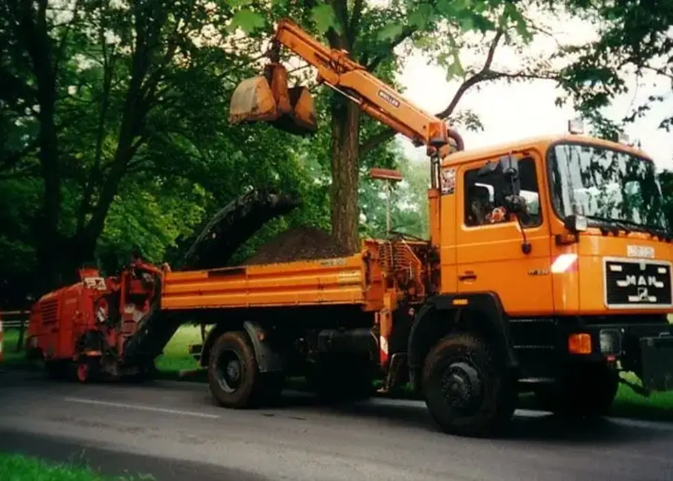Ein Lkw lädt große Mengen Sand ab um die Fahrbahn damit zu reparieren