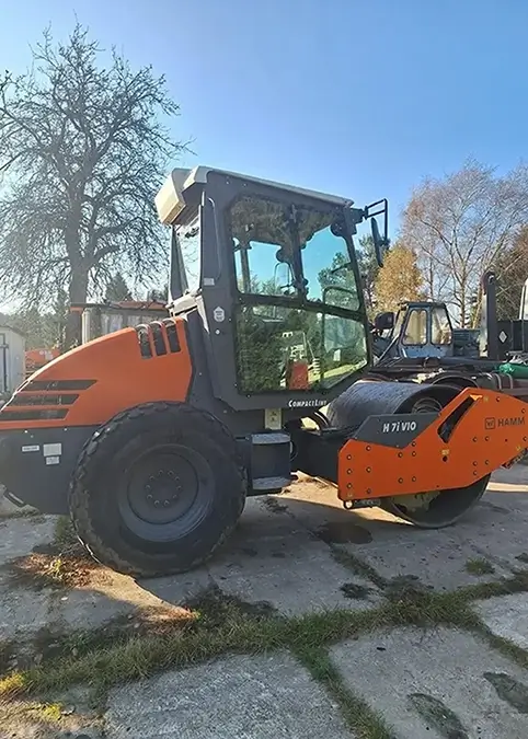 Ein sehr moderne Traktor der Firma Hamm steht auf einem Parkplatz