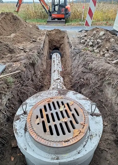 Ein neuer Regenentwässerungsgraben wird an einer kleinen Strasse angelegt